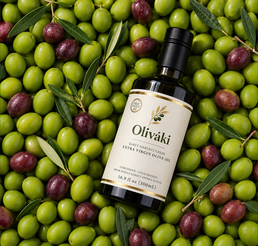 Oliváki Early Harvest Greek Extra Virgin Olive Oil bottle surrounded by fresh green and purple olives