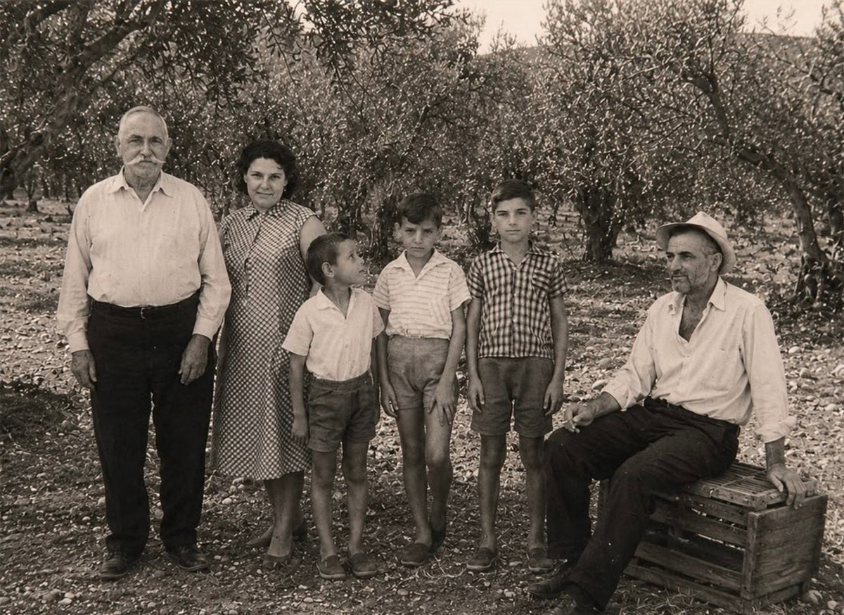 Vintage black and white photo of a family standing in an olive grove.